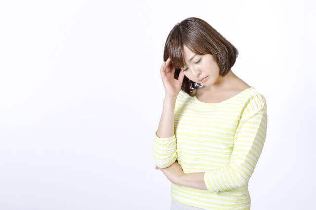 本番強要に頭をかかえる女性の様子の画像